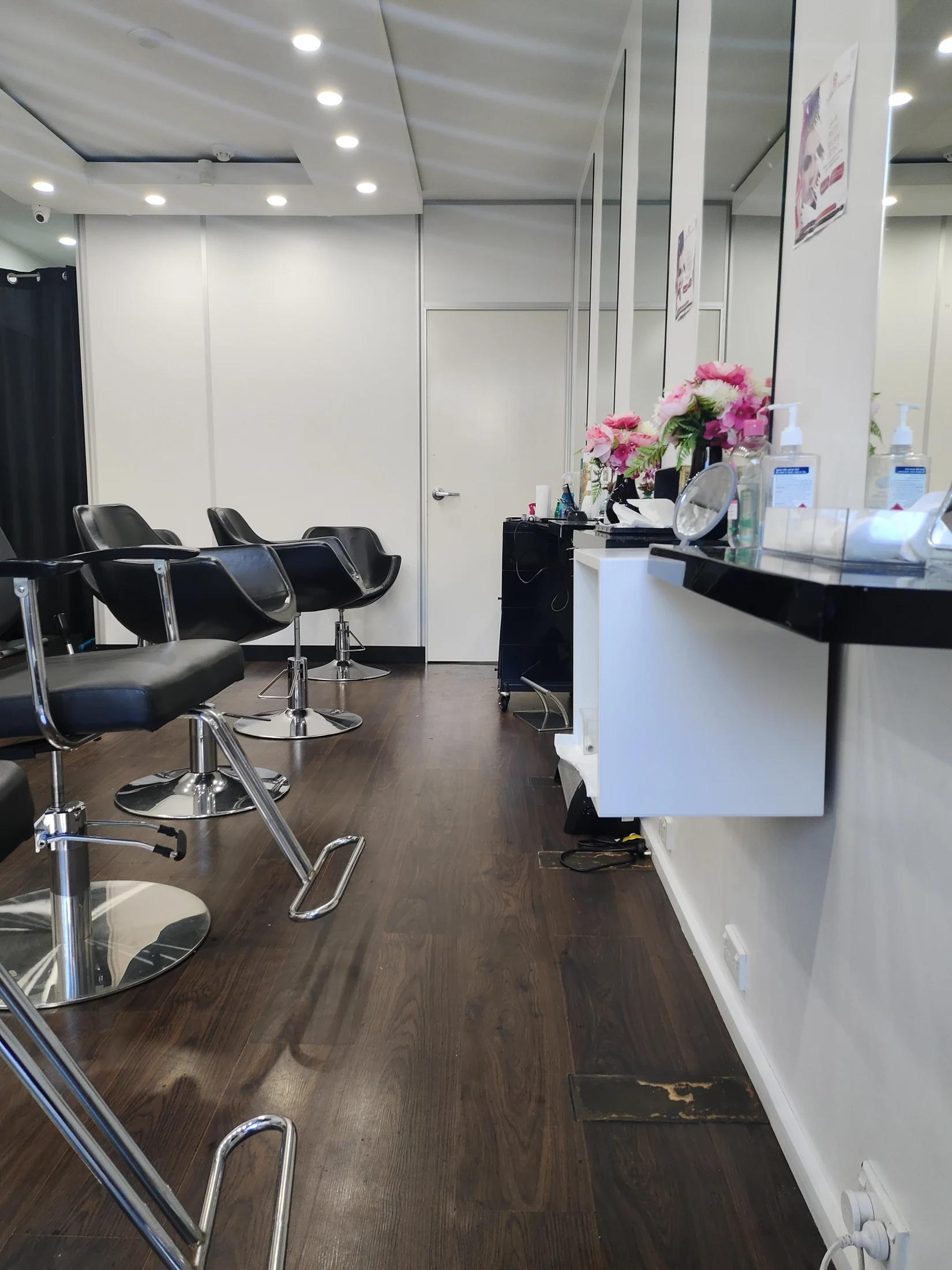 The salon floor read down its full length &mdash; chairs, mirrors and counter receding to the far wall
